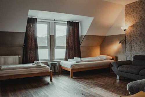 een kamer met 2 bedden, een bank en een raam bij 3-Zimmer-Oase-Cityapartment Bielefeld Mitte 401 in Bielefeld