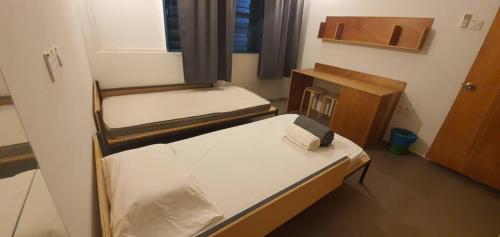 a small room with two beds and a desk at YWCA Kuala Lumpur in Kuala Lumpur