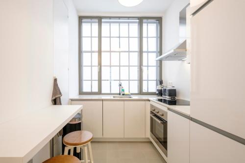 a kitchen with white cabinets and a sink at THE GOOD FLATS in Brussels