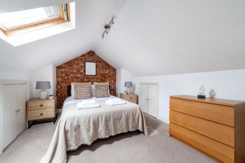 um quarto com uma cama e uma parede de tijolos em The Harlesden Villas em Londres