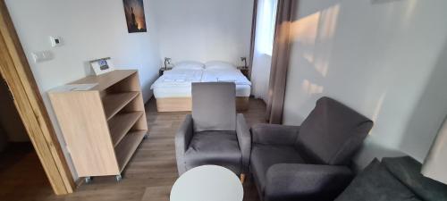 a living room with a chair and a bed at Apartmán u Toma in Frýdlant nad Ostravicí