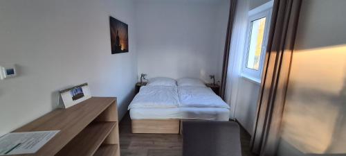 a small bedroom with a bed and a desk at Apartmán u Toma in Frýdlant nad Ostravicí