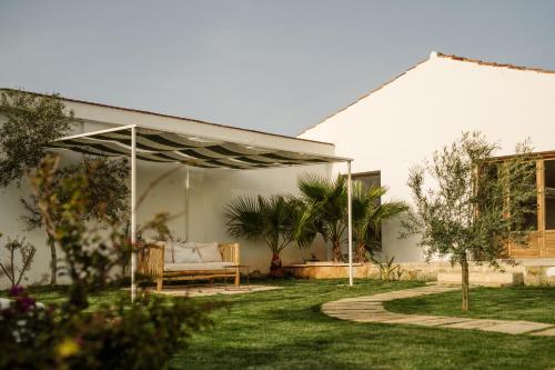 a garden with a couch under a pergola at Amagatay Luxury Boutique Hotel - Adults Only in Alaior