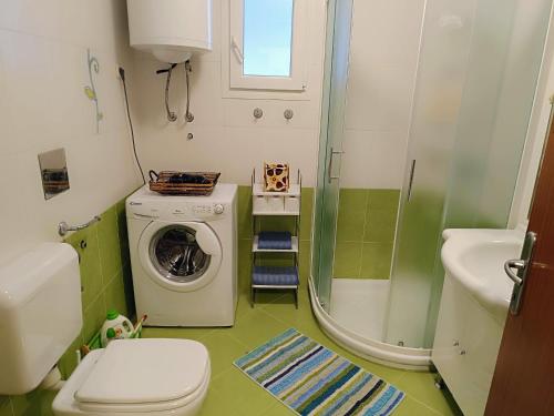 a bathroom with a washing machine and a sink at Porec Travel Stop in Poreč