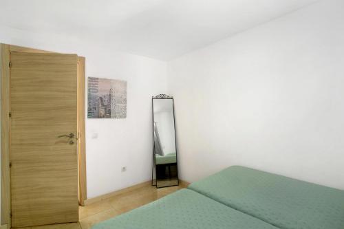 ein Schlafzimmer mit einem grünen Bett und einem Spiegel in der Unterkunft Atico vecindario, aeropuerto in Cruce de Arinaga