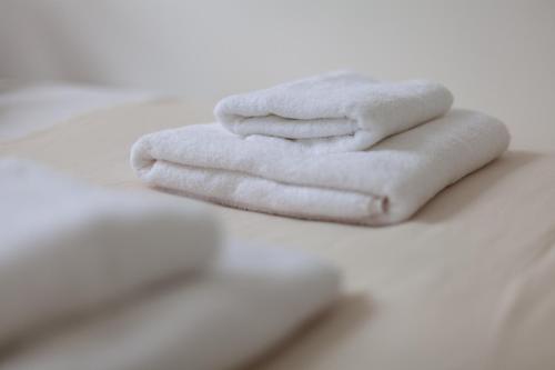 uma pilha de toalhas brancas sentadas numa mesa em The Harlesden Villas em Londres