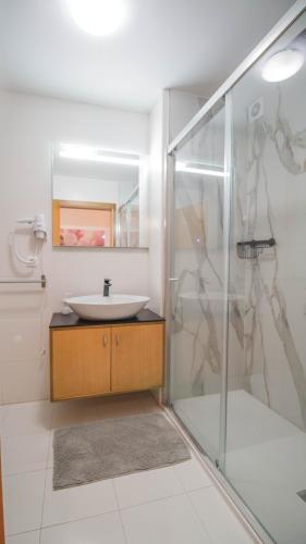 a bathroom with a sink and a shower at Casas e Quintas de Praia in Praia da Barra