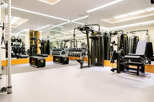 a gym with several treadmills and exercise equipment at The Connaught, Maybourne in London