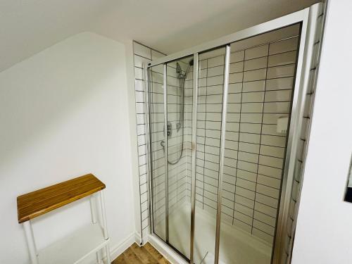 a shower with a glass door in a bathroom at West Street Mews - Serviced Accommodation in Exeter