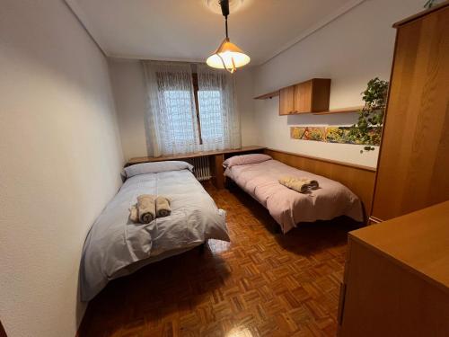 1 dormitorio con 2 camas y ventana en Luminoso piso grande con garaje en el centro., en Santander