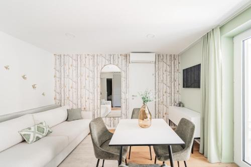 a living room with a white couch and a table at Das Haidensee in Glanegg