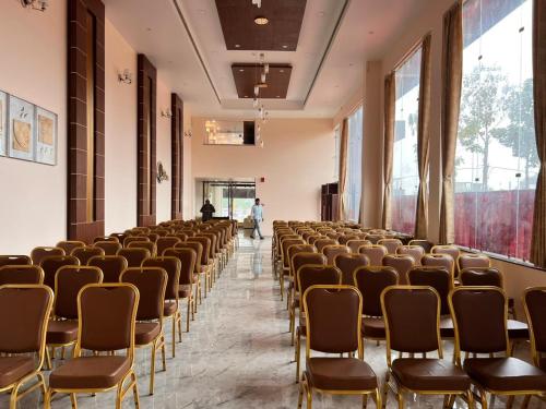 une rangée de chaises dans une pièce avec des personnes en arrière-plan dans l'établissement Krishna Vatika Hotel, à Shivāpur