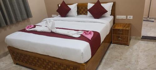 twee bedden in een hotelkamer met handdoeken erop bij Krishna Vatika Hotel in Shivāpur