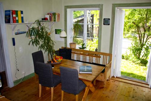 B&B Eco-Village 12 min from city في ستوكهولم: غرفة طعام مع طاولة وكراسي خشبية
