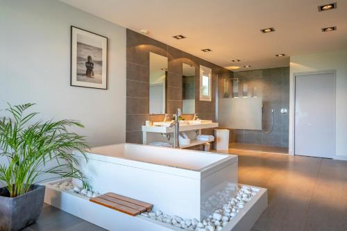 une salle de bain avec une grande baignoire et un lavabo dans l'établissement Lafitenia Resort, à Saint-Jean-de-Luz