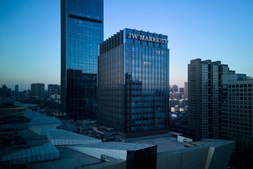 a large building with a sign on it in a city at JW Marriott Hotel Taiyuan in Taiyuan