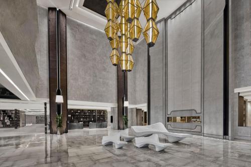 a lobby with chairs and a large chandelier at JW Marriott Hotel Taiyuan in Taiyuan