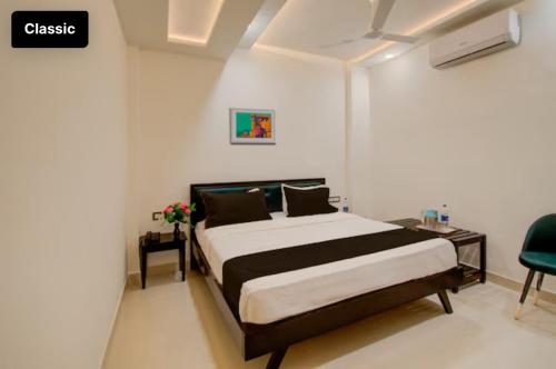 a bedroom with a bed and a table and a chair at Hotel Giriraj Palace in Jaipur