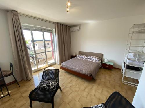 1 dormitorio con cama, sillas y balcón en Appartamento 44, en Novara