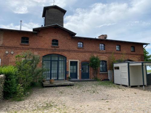 un edificio di mattoni con una torre sopra di Ostsee-Landhausblick zw Rostock und Wismar a Neuburg