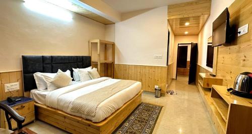 een slaapkamer met een groot bed in een kamer bij HOTEL THE CLOUD HILLS in Dharamshala