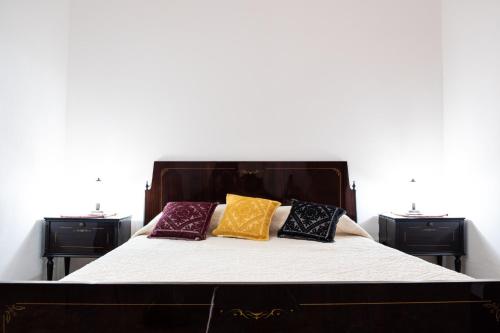 a bed with four pillows on it in a room at Sa Burra Guest House in Gadoni