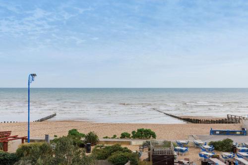 an empty beach with chairs and the ocean at Chic 2-Bed Seafront Haven Near Felpham Beach in Felpham