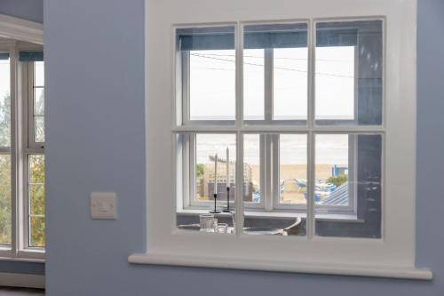 a window in a room with a view of a building at Chic 2-Bed Seafront Haven Near Felpham Beach in Felpham
