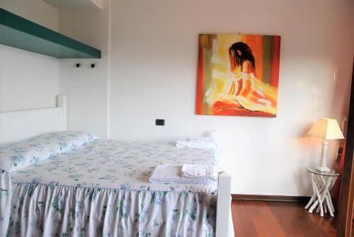 um quarto com uma cama com um quadro na parede em VILLA ROMANTIC COVE vista mozzafiato sul mare em Latina