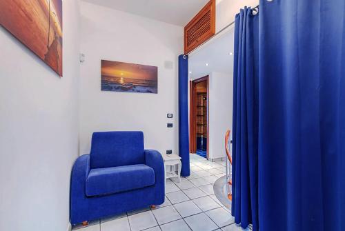 uma cadeira azul num quarto com uma cortina azul em VILLA ROMANTIC COVE vista mozzafiato sul mare em Latina