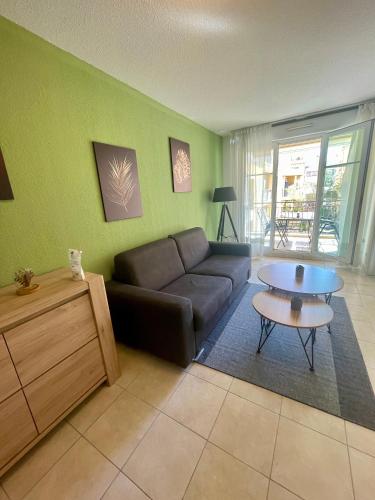 un salon avec un canapé et une table dans l'établissement Royal Plazza, beau T2 centre ville, parking, à Menton