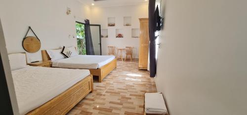 a room with two beds and a table and chairs at Sunrise Dốc Lết in Ninh Hai