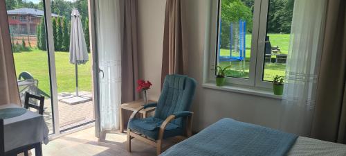 a room with a chair and a bed and windows at Apartmán u Toma in Frýdlant nad Ostravicí