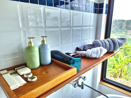 a shelf with two bottles of soap and a window at PIDA COFFEE FARM LODGE in Phumĭ Pu Pal