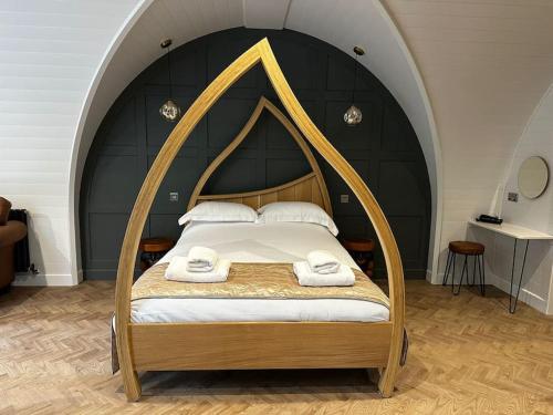 a bedroom with a bed with an arched ceiling at Badger at Owlet Hideaway - with Hot Tub, near York in Seaton Ross