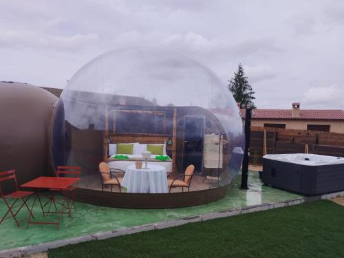 a bedroom in a dome tent with a table and chairs at COSMOVEROS - Hotel Burbuja in Pedraza-Segovia