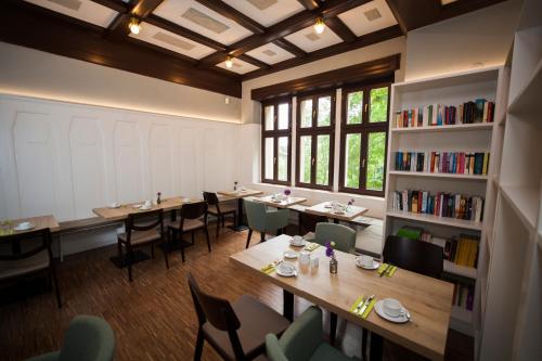 a restaurant with tables and chairs and a book shelf at Philippus Inklusionshotel Leipzig in Leipzig