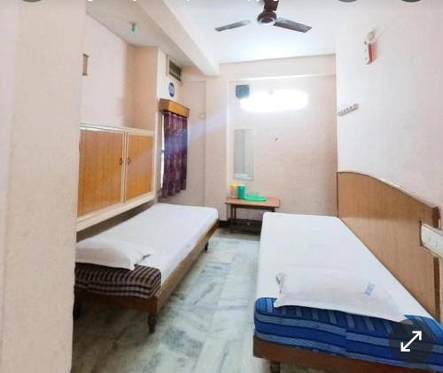 Pokój szpitalny z 2 łóżkami i sufitem w obiekcie Ganesh Lodge w mieście Tirupati