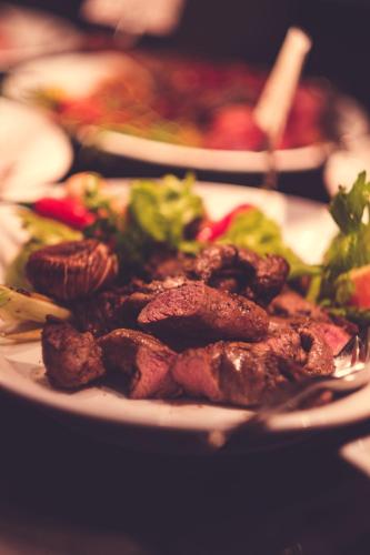 a plate of food with meat and vegetables on a table at Spidsbergseter Resort Rondane in Venabygd