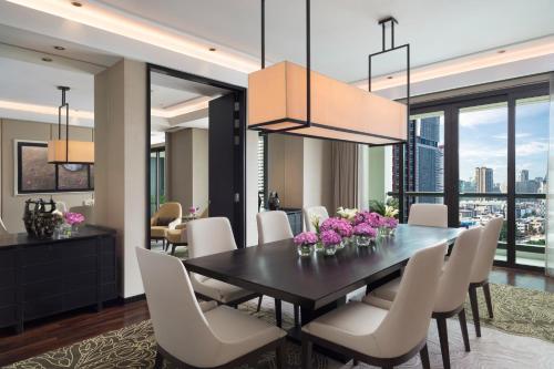 a dining room with a black table and white chairs at Siam Kempinski Hotel Bangkok - SHA Extra Plus Certified in Bangkok