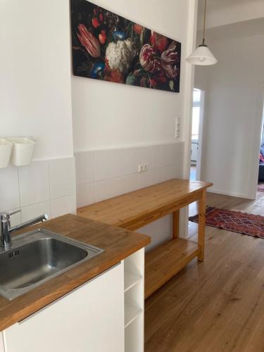 3 Zimmer-Lounge in KÖLN Sülz mit Küche, Balkon, 2 Bäder في كولونيا: مطبخ مع حوض وأعلى كونتر خشبي