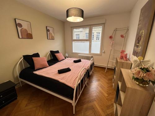um quarto com uma cama com lençóis cor-de-rosa e uma janela em Steftwo em Valenciennes