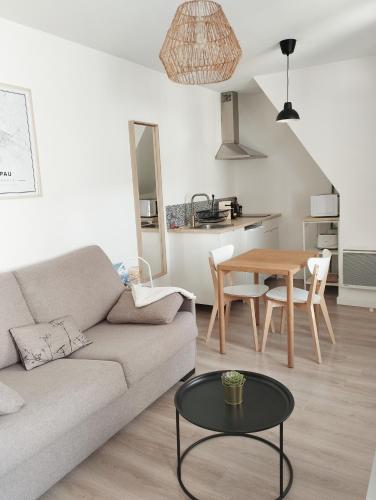un salon avec un canapé et une table dans l'établissement Stylish Nest: studio tout confort au cœur de Pau, à Pau