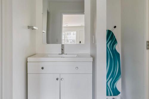 a bathroom with a sink and a mirror and a surfboard at Blueground Oakland ac walk to dining shops SFO-1705 in Oakland