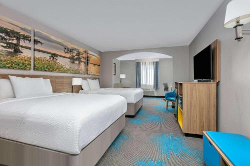 A bed or beds in a room at Days Inn & Suites by Wyndham Cabot