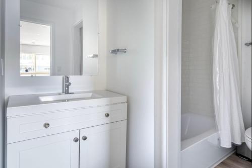 een witte badkamer met een wastafel en een spiegel bij Blueground Oakland ac near Jack London Sq SFO-1706 in Oakland