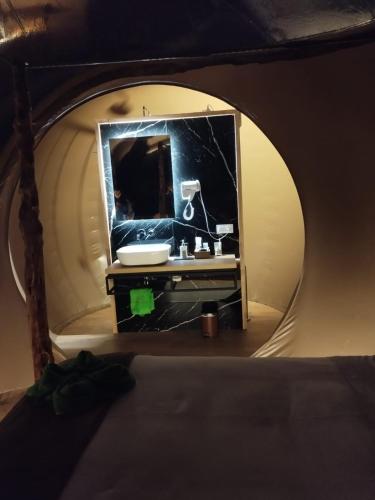 a bathroom with a mirror and a sink in a tent at COSMOVEROS - Hotel Burbuja in Pedraza-Segovia