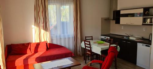 Apartamento pequeño con cocina y mesa con cama roja. en Apartmán u Toma, en Frýdlant nad Ostravicí