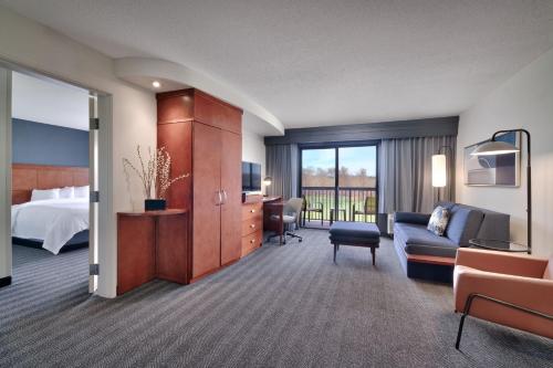 a hotel room with a bed and a couch at Courtyard by Marriott Johnson City in Johnson City
