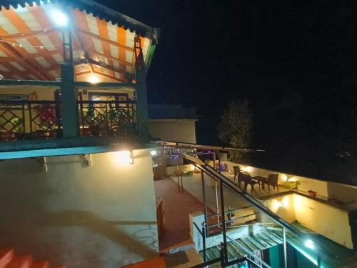 a building with a swimming pool at night at Vineet's homestay in Mukteshwar